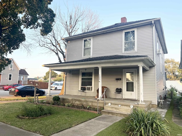 400 Burlington Ave, Logansport, IN 46947 - american foursquare style home featuring covered porch, a chimney, a front lawn, and cooling unit