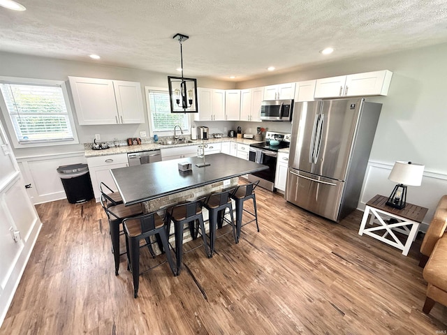 3833 Clover Dr, Newburgh, IN 47630 - kitchen featuring stainless steel appliances, a textured ceiling, wood finished floors, white cabinets, and recessed lighting