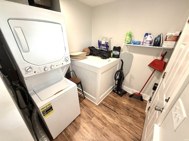 3833 Clover Dr, Newburgh, IN 47630 - laundry room featuring stacked washing machine and dryer, wood finished floors, and baseboards
