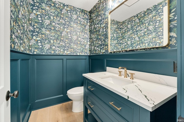 121 Jadis Ct, Fort Wayne, IN 46845 - bathroom with wallpapered walls, a wainscoted wall, toilet, vanity, and wood finished floors