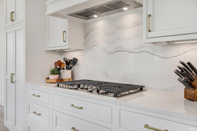 121 Jadis Ct, Fort Wayne, IN 46845 - kitchen with premium range hood, stainless steel gas cooktop, white cabinetry, and light stone counters