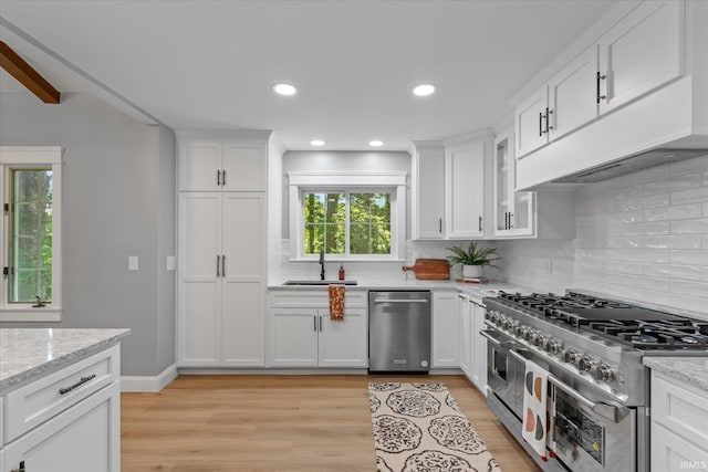 633 S Ravencrest Ave, Bloomington, IN 47401 - kitchen with stainless steel appliances, a sink, light wood-style floors, decorative backsplash, and recessed lighting