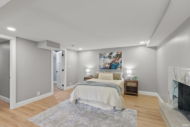 633 S Ravencrest Ave, Bloomington, IN 47401 - bedroom with light wood-type flooring, baseboards, a premium fireplace, and recessed lighting