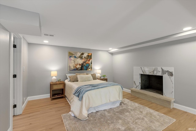633 S Ravencrest Ave, Bloomington, IN 47401 - bedroom featuring light wood-type flooring, baseboards, recessed lighting, and a high end fireplace