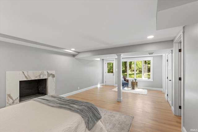 633 S Ravencrest Ave, Bloomington, IN 47401 - bedroom with baseboards, light wood-style floors, recessed lighting, ornate columns, and a high end fireplace