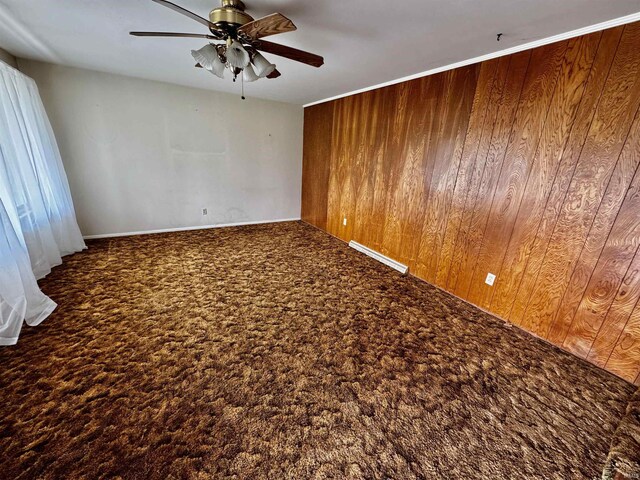 2940 19th St, Columbus, IN 47201 - carpeted empty room featuring ceiling fan and wood walls