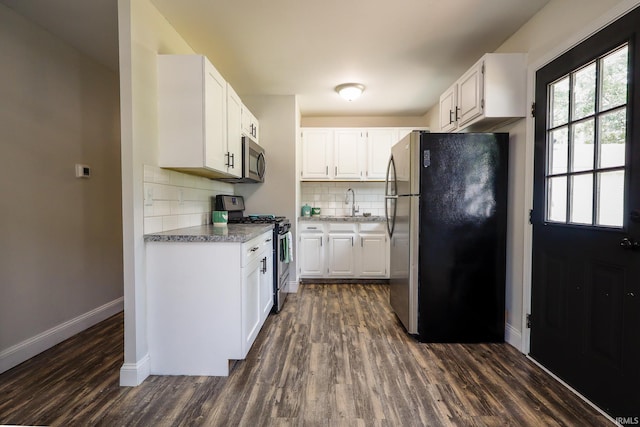 113 W Berkeley Ave, Evansville, IN 47710 - kitchen with appliances with stainless steel finishes, baseboards, dark wood-style floors, tasteful backsplash, and white cabinets
