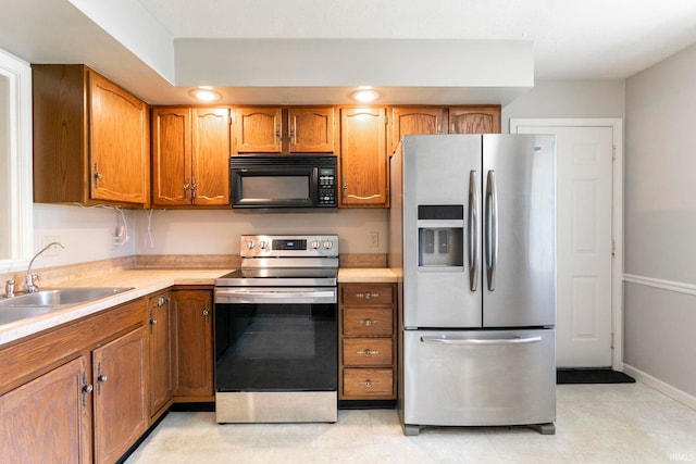 5709 Bayswater Ct, South Bend, IN 46614 - kitchen with stainless steel appliances, a sink, light countertops, and brown cabinets