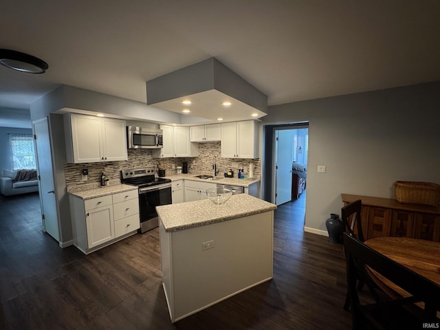 1414 Spear St, Rochester, IN 46975 - kitchen with appliances with stainless steel finishes, backsplash, dark wood-style floors, white cabinetry, and baseboards