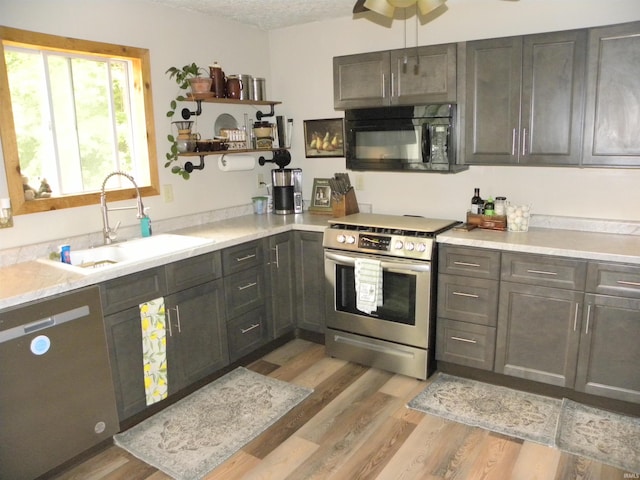 3116 Truesdel Rd, Gosport, IN 47433 - kitchen with appliances with stainless steel finishes, a sink, light wood finished floors, light countertops, and open shelves