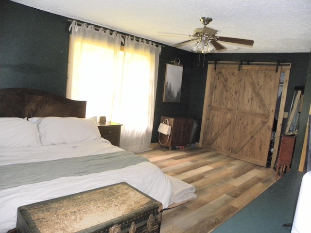 3116 Truesdel Rd, Gosport, IN 47433 - bedroom with multiple windows, wood finished floors, a barn door, and ceiling fan