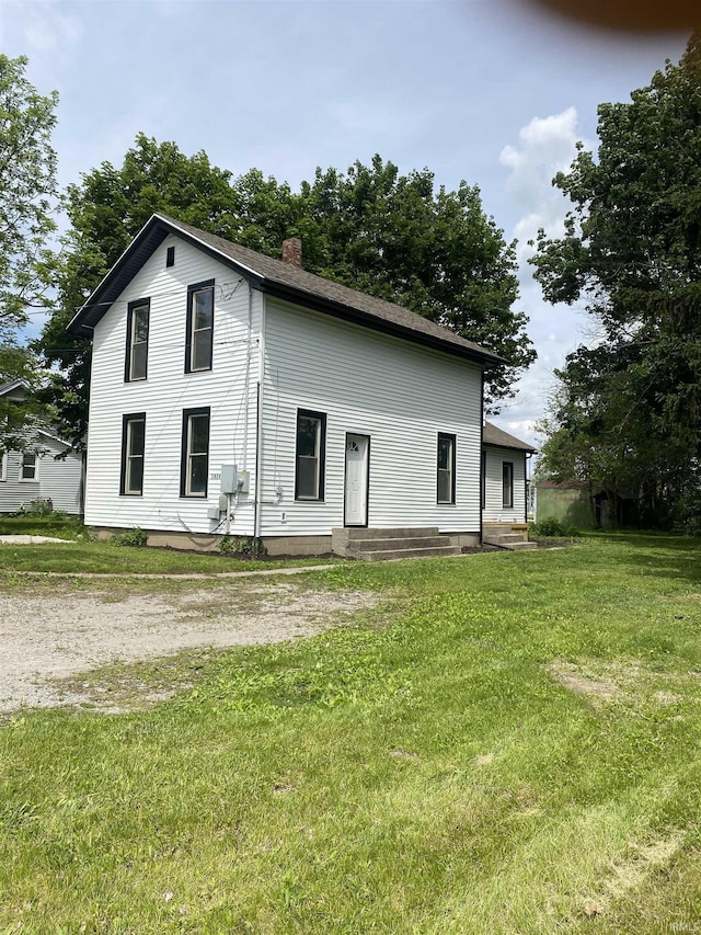 1824 Boxcar Ln, Auburn, IN 47606 - rear view of house with a chimney, a lawn, and entry steps