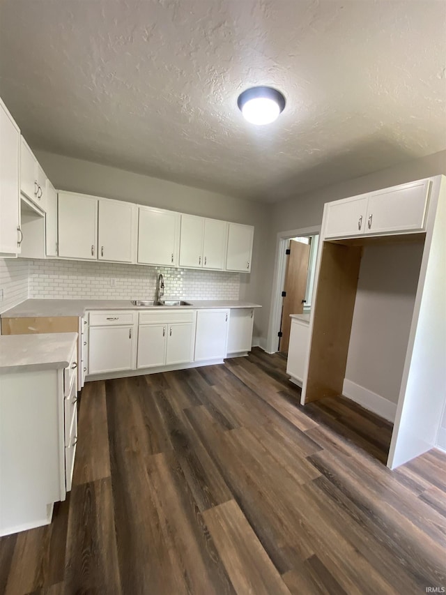 1824 Boxcar Ln, Auburn, IN 47606 - kitchen featuring a sink, decorative backsplash, white cabinets, a textured ceiling, and dark wood finished floors