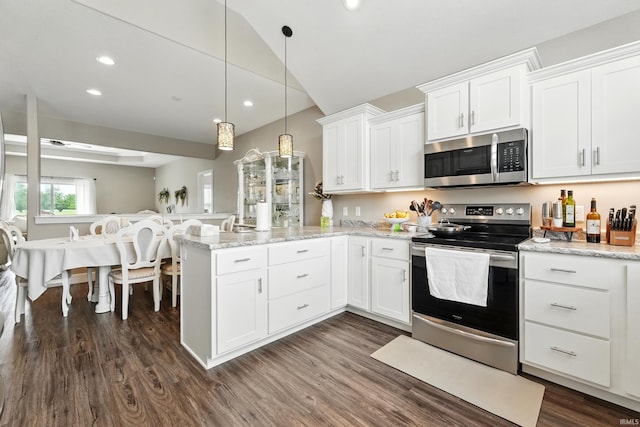 17009 Hamptons Pkwy, New Haven, IN 46774 - kitchen featuring stainless steel appliances, a peninsula, white cabinets, lofted ceiling, and dark wood finished floors