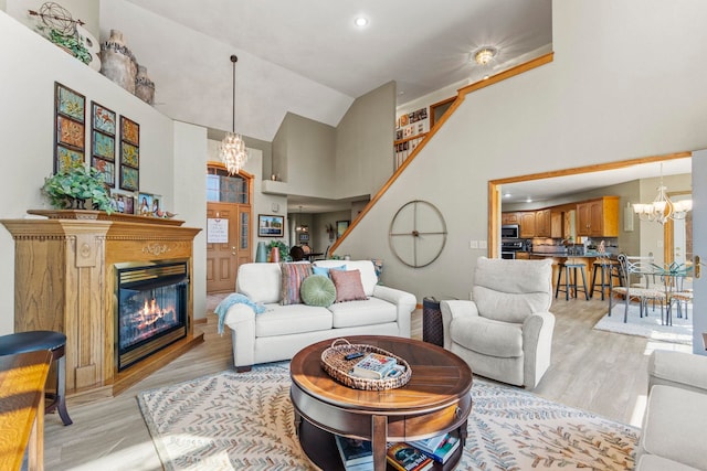 6378 N 100 E, Ossian, IN 46777 - living room featuring a chandelier, high vaulted ceiling, light wood-style floors, a glass covered fireplace, and recessed lighting
