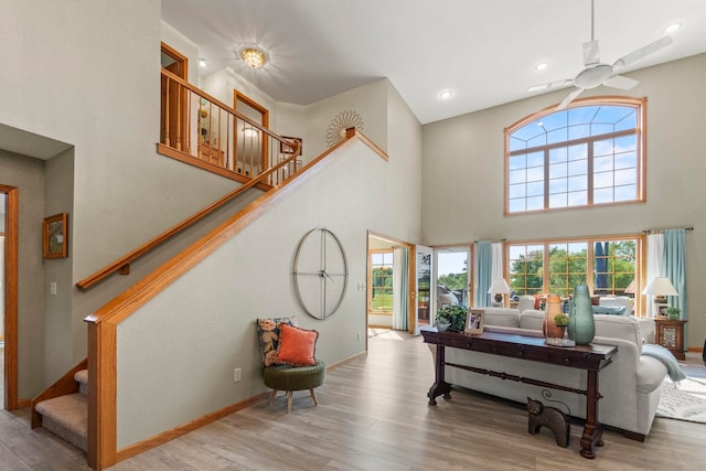 6378 N 100 E, Ossian, IN 46777 - living room featuring a ceiling fan, a towering ceiling, wood finished floors, stairs, and baseboards