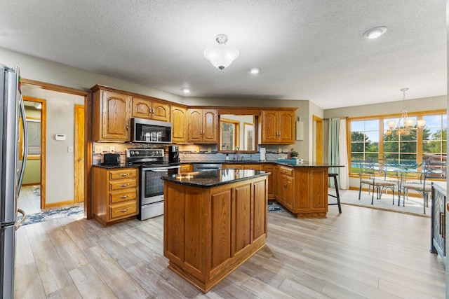 6378 N 100 E, Ossian, IN 46777 - kitchen with stainless steel appliances, a sink, light wood-style floors, brown cabinets, and a kitchen island