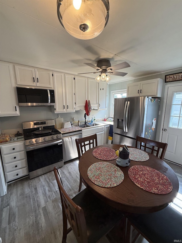 2520 Foxhall Dr, Lafayette, IN 47909 - kitchen with appliances with stainless steel finishes, white cabinets, a sink, wood finished floors, and a ceiling fan