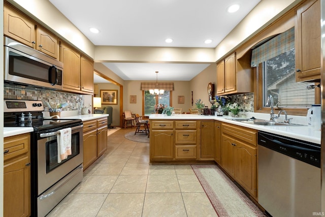1114 Packard Pl, Auburn, IN 46706 - kitchen with stainless steel appliances, a sink, a peninsula, a chandelier, and tasteful backsplash