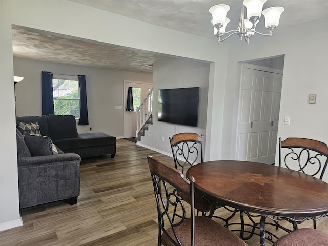 1326 Stag Dr, Fort Wayne, IN 46804 - dining space featuring wood finished floors, stairs, a chandelier, and baseboards