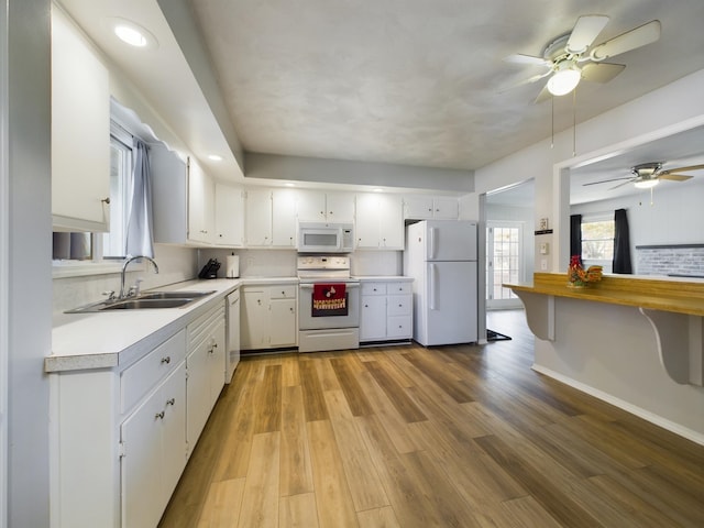 1326 Stag Dr, Fort Wayne, IN 46804 - kitchen with white appliances, a sink, light countertops, white cabinetry, and healthy amount of natural light
