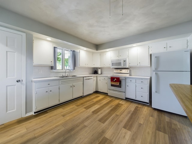 1326 Stag Dr, Fort Wayne, IN 46804 - kitchen featuring white appliances, a sink, light countertops, white cabinets, and light wood-style floors