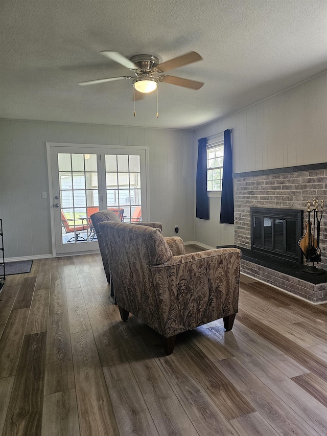 1326 Stag Dr, Fort Wayne, IN 46804 - living room featuring dark wood-style flooring, a ceiling fan, a textured ceiling, a brick fireplace, and baseboards