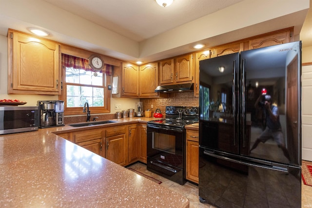 54363 Adrian Ct, Osceola, IN 46561 - kitchen with black appliances, a sink, under cabinet range hood, brown cabinets, and tasteful backsplash