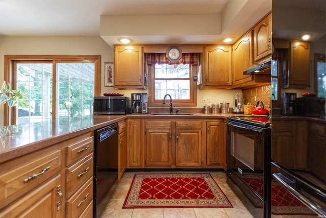 54363 Adrian Ct, Osceola, IN 46561 - kitchen with black appliances, a sink, under cabinet range hood, light tile patterned floors, and brown cabinets