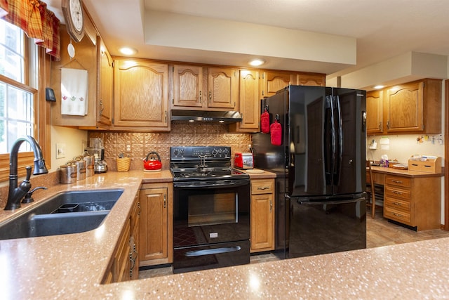 54363 Adrian Ct, Osceola, IN 46561 - kitchen with black appliances, under cabinet range hood, a sink, backsplash, and brown cabinets
