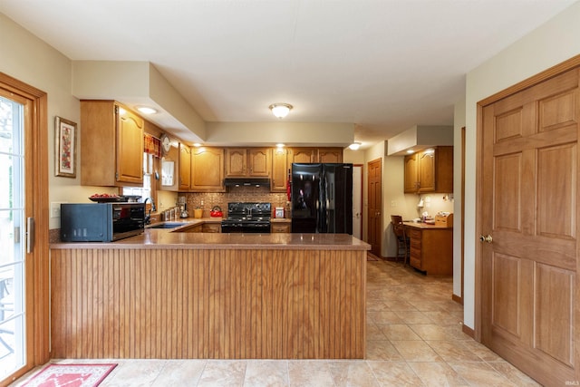 54363 Adrian Ct, Osceola, IN 46561 - kitchen with black appliances, under cabinet range hood, a peninsula, a sink, and backsplash