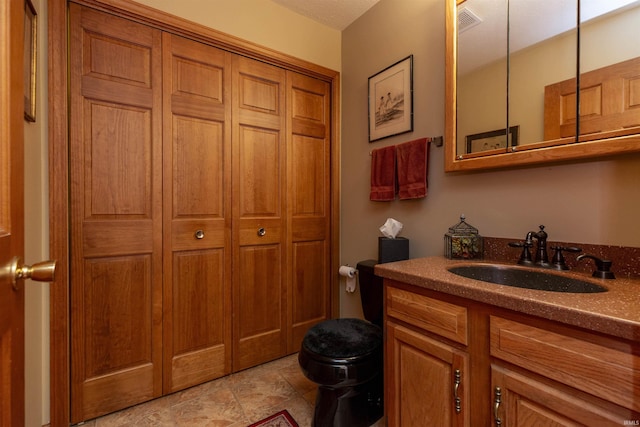 54363 Adrian Ct, Osceola, IN 46561 - bathroom with toilet, vanity, a closet, and stone finish floors