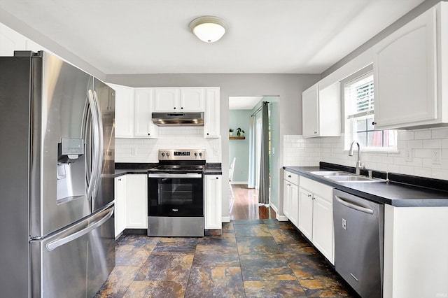 843 S Lantern Ln, Ellettsville, IN 47401 - kitchen featuring appliances with stainless steel finishes, a sink, under cabinet range hood, dark countertops, and tasteful backsplash