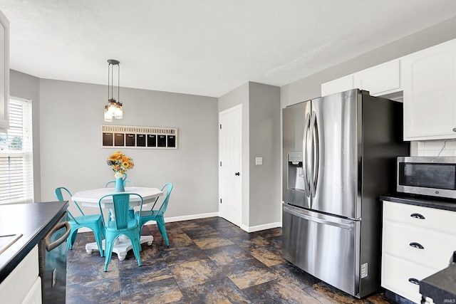 843 S Lantern Ln, Ellettsville, IN 47401 - kitchen featuring appliances with stainless steel finishes, baseboards, white cabinetry, dark stone finish floors, and decorative light fixtures