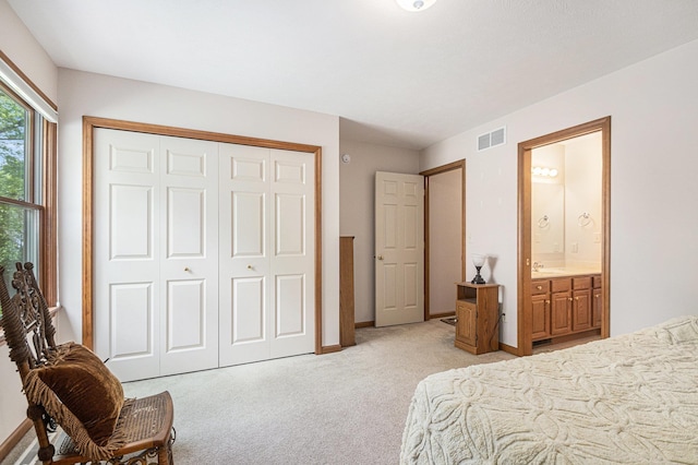 58078 Windsong Dr, Elkhart, IN 46517 - bedroom featuring light carpet, a closet, ensuite bath, baseboards, and a sink
