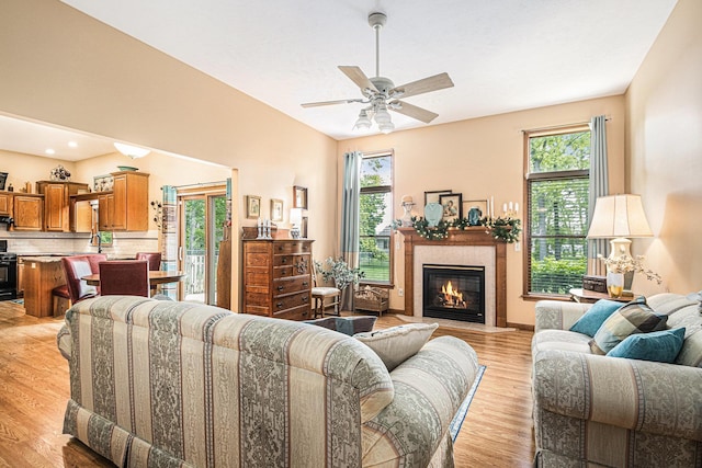 58078 Windsong Dr, Elkhart, IN 46517 - living room with healthy amount of natural light, light wood-style floors, a ceiling fan, and a fireplace with flush hearth