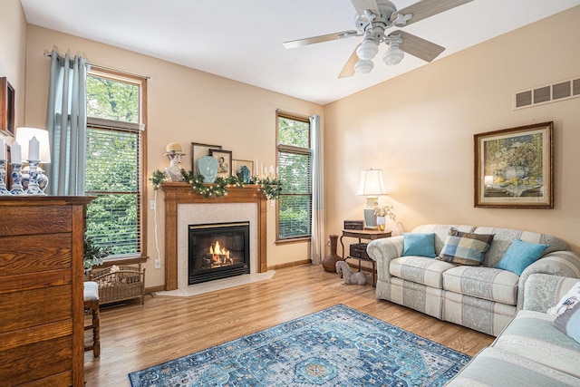 58078 Windsong Dr, Elkhart, IN 46517 - living room featuring wood finished floors, a tiled fireplace, plenty of natural light, and lofted ceiling