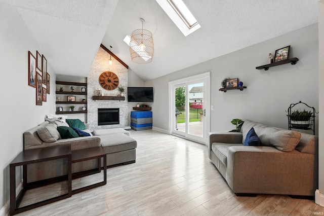 2906 Easton Ridge Pl, Fort Wayne, IN 46818 - living room with a skylight, a fireplace, light wood-style floors, high vaulted ceiling, and a textured ceiling