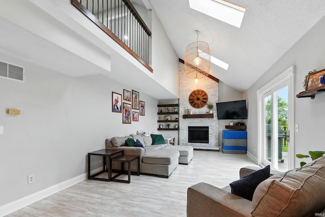 2906 Easton Ridge Pl, Fort Wayne, IN 46818 - living room with a skylight, high vaulted ceiling, light wood-type flooring, a fireplace, and baseboards