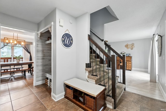 2906 Easton Ridge Pl, Fort Wayne, IN 46818 - stairway featuring a chandelier, baseboards, and tile patterned flooring