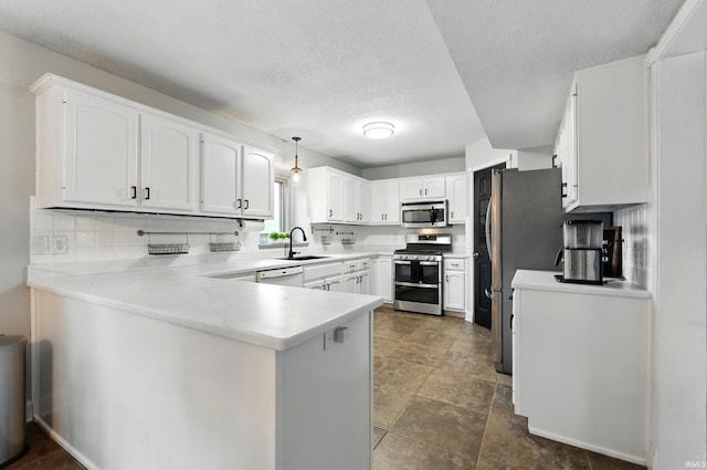 2906 Easton Ridge Pl, Fort Wayne, IN 46818 - kitchen with appliances with stainless steel finishes, a sink, a peninsula, tasteful backsplash, and a textured ceiling