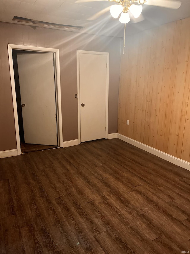 303 E N St, Winslow, IN 47598 - unfurnished bedroom with dark wood-style flooring, baseboards, and a ceiling fan