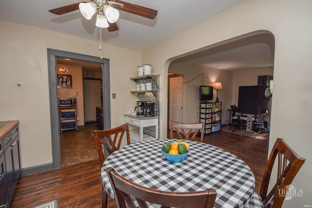 1816 W 13th St, Muncie, IN 47302 - dining space with arched walkways, ceiling fan, and dark wood finished floors