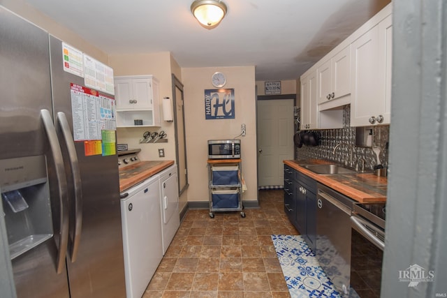 1816 W 13th St, Muncie, IN 47302 - kitchen with appliances with stainless steel finishes, wood counters, a sink, white cabinetry, and washing machine and dryer