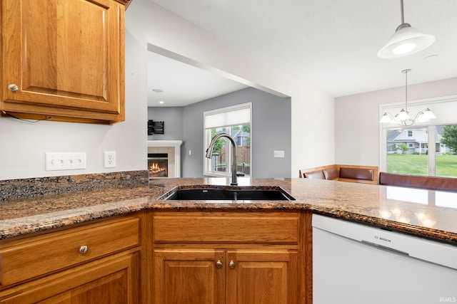 3564 Westport Dr, New Haven, IN 46774 - kitchen featuring dishwasher, a sink, dark stone counters, and brown cabinetry