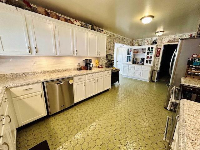 27 N Edwards St, Worthington, IN 47471 - kitchen with dishwasher, wallpapered walls, white cabinets, and freestanding refrigerator