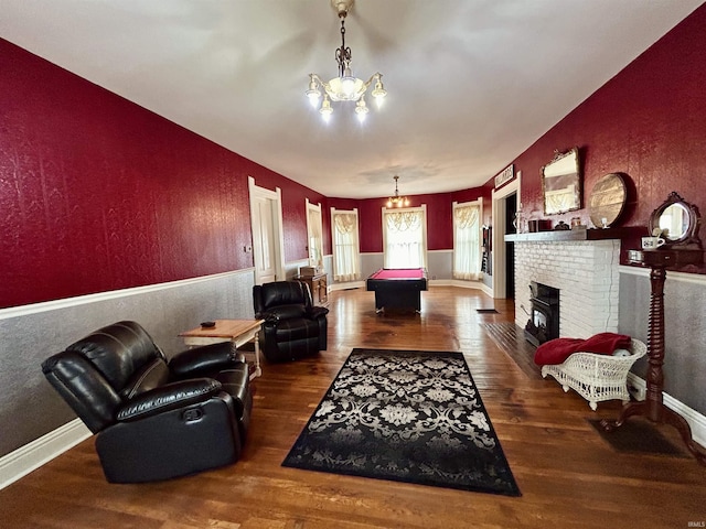 27 N Edwards St, Worthington, IN 47471 - living room with a chandelier, wood finished floors, baseboards, a brick fireplace, and a textured wall