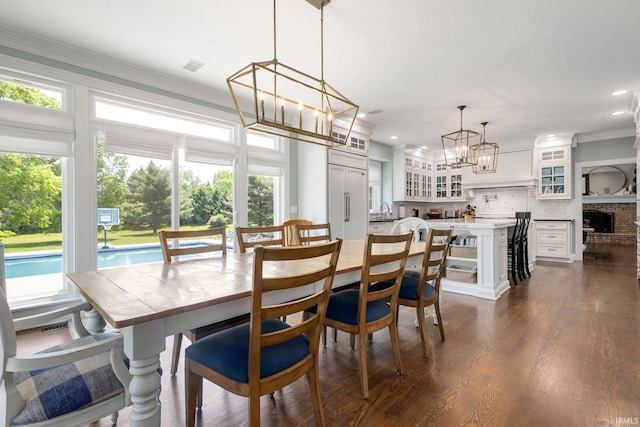 11070 Birch Lake Dr, Granger, IN 46530 - dining space with a chandelier, dark wood-style floors, recessed lighting, ornamental molding, and a brick fireplace