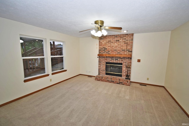 904 Brookridge Ct, Lafayette, IN 47909 - unfurnished living room with carpet flooring, baseboards, ceiling fan, a textured ceiling, and a brick fireplace