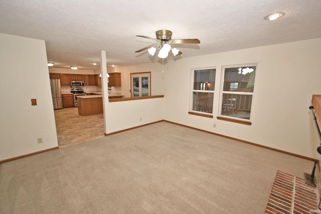 904 Brookridge Ct, Lafayette, IN 47909 - unfurnished living room featuring light colored carpet, baseboards, a ceiling fan, and a textured ceiling